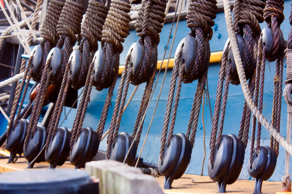 Pulleys and ropes on a ship, illustrating traditional rigging equipment for lifting operations.